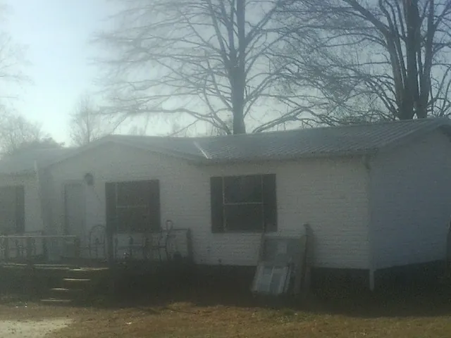 New metal roof on a white painted brick home on a foggy morning in Union City